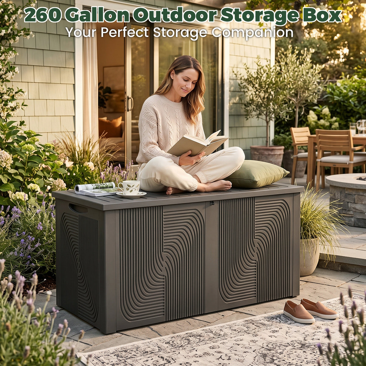 Black 260 gallon outdoor storage box with sculptural wave design in a landscaped patio seating area.