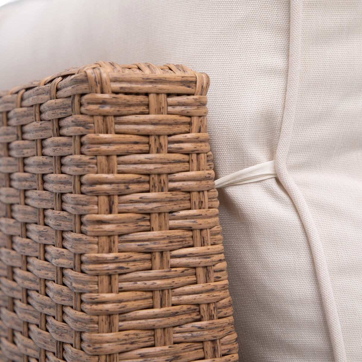 Close-up of natural brown double half-round wicker weaving beside a beige sofa cushion