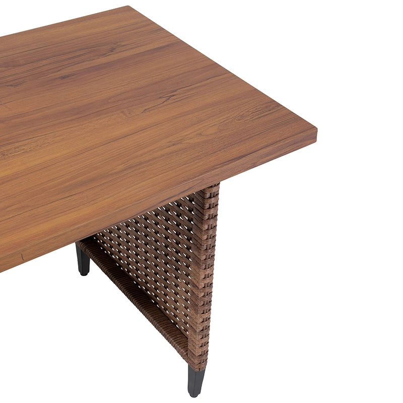 Corner detail of rectangular wood-look patio tabletop and wicker support