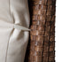 Close-up of beige sofa cushion attachment against woven wicker frame
