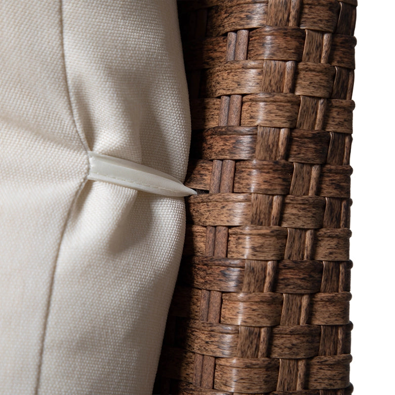 Close-up of beige sofa cushion attachment against woven wicker frame