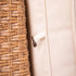 Close-up of beige outdoor sofa cushion attachment against woven wicker backrest