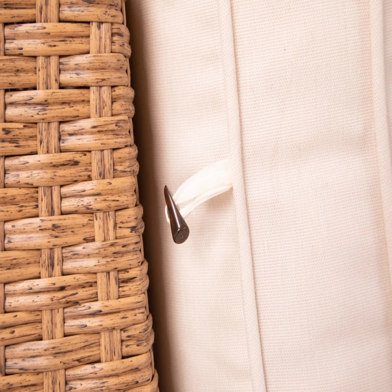Close-up of beige outdoor sofa cushion attachment against woven wicker backrest