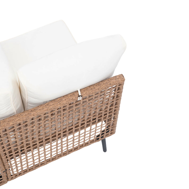 Side view of outdoor sectional sofa module with beige cushions and woven base