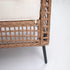 Side detail of wicker sectional sofa frame with black tapered metal legs