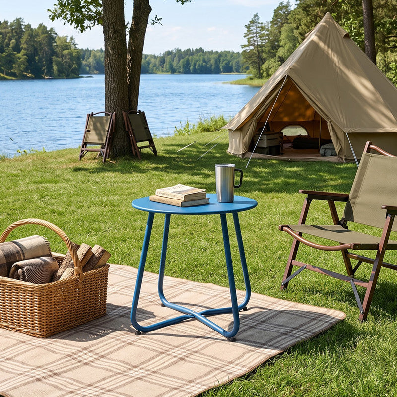 Peacock blue outdoor metal round side table placed beside outdoor chairs in a garden setting